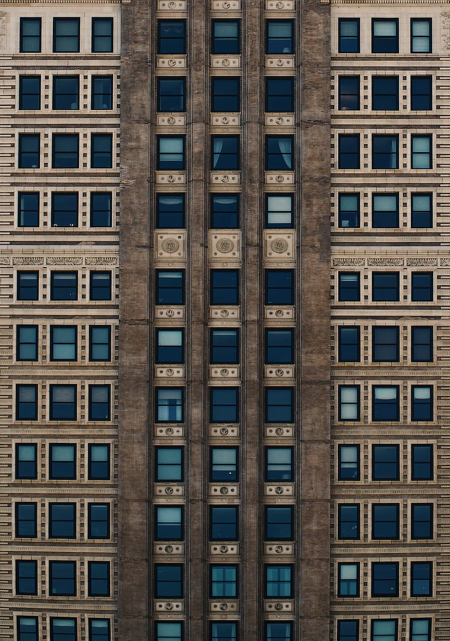 brown concrete building with blue glass windows during daytime, closeup photo of blue and brown building HD wallpaper