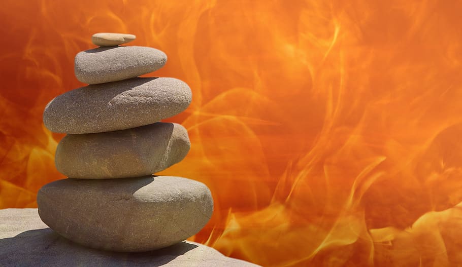 gray cairn stones with orange and yellow flames background digital wallpaper HD wallpaper