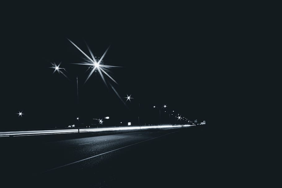 grayscale photography of street lights, lighted road during nigth