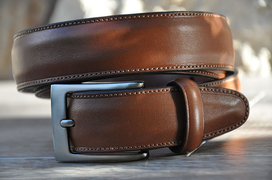 close up photography of rolled brown leather belt, menswear, man