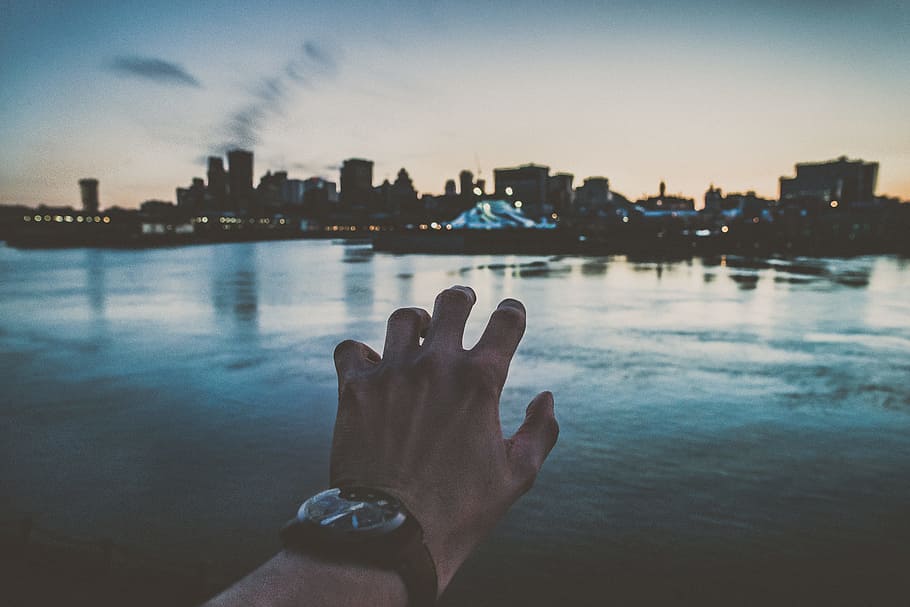 person's left hand reaching city scapes photography, illusion of person grabbing cityscape while wearing black analog watch, HD wallpaper