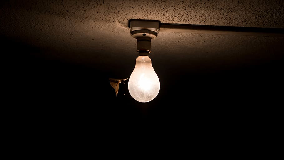 white light bulb covered by dark, photography of turn-on bulb during nightime