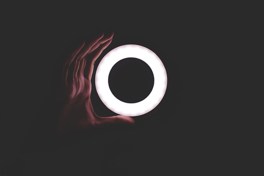 round white LED light, person holding round white neon light