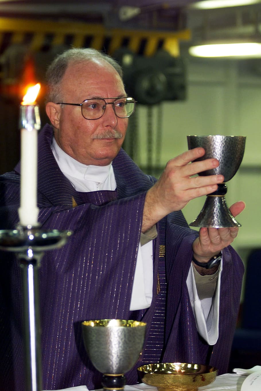 priest holding cup near candle, Mass, Roman Catholic, Catholic, Faith
