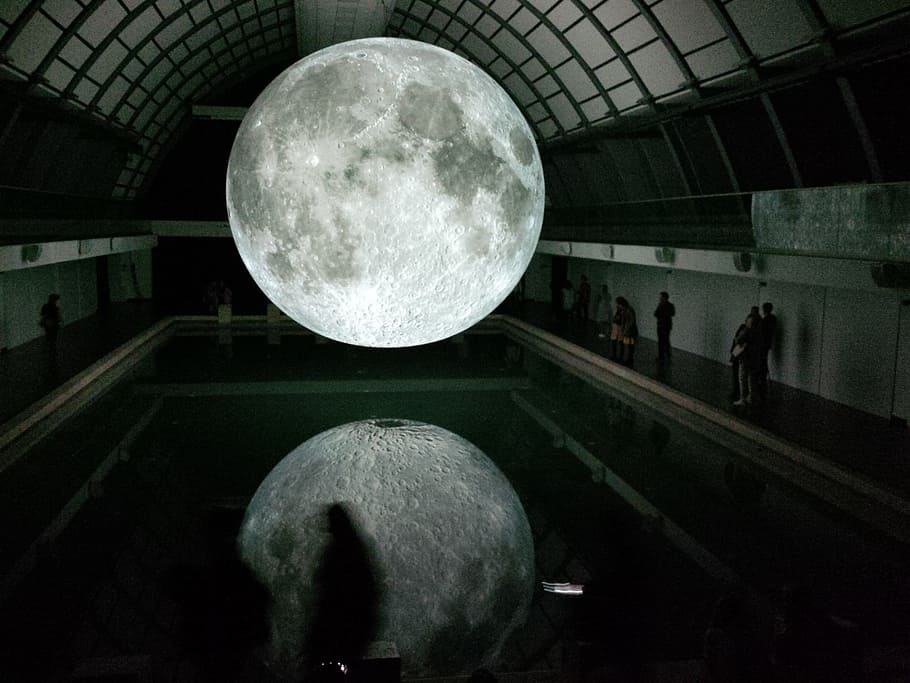 Photo of Moon Hologram Floating on Water Near People Inside Room HD wallpaper