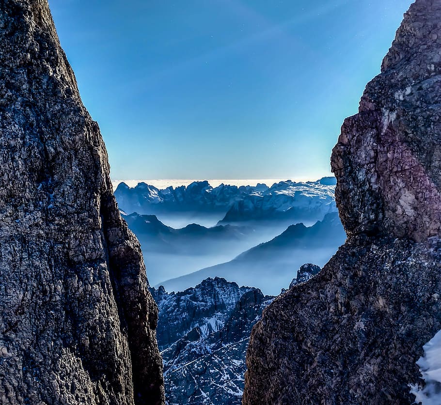rock mountains with mist in between rock canyon view during daytime, mountain ranges surrounded by sea of clouds HD wallpaper