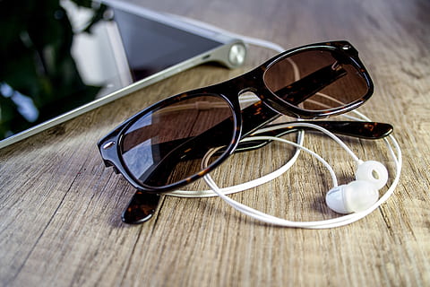 Wayfarer sunglasses near canalbuds on wooden surface, tablet HD wallpaper