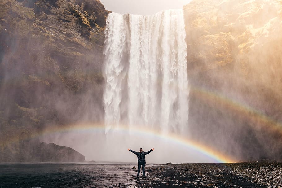person standing in front of waterfall during daytime, rainbow HD wallpaper