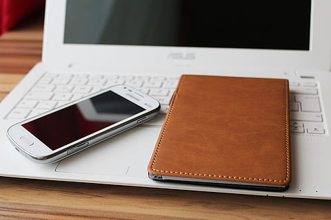 turned off white Samsung Android smartphone beside brown leather notebook on top of white turned off Asus laptop HD wallpaper