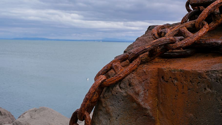 large rusty chains on stone overlooking sea during day, ocean HD wallpaper