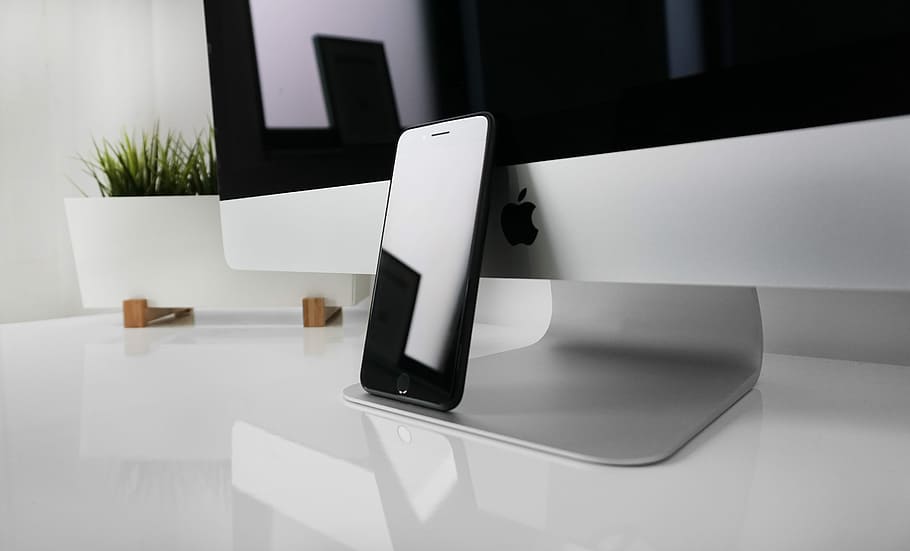 black iPhone 7 leaning on silver iMac, space gray iPhone 7, technology