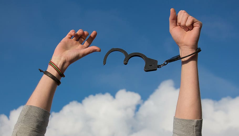 person freeing a handcuff with a view of blue sky, dom, hands