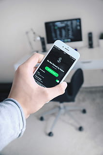 person holding iPhone showing Spotify application, person holding iPhone displaying Do Not Disturb by Adam HD wallpaper