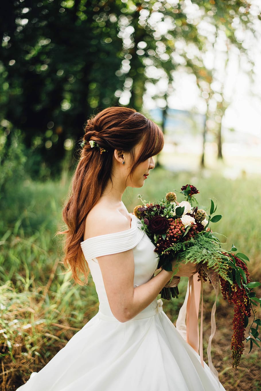 woman wearing white off-shoulder wedding gown wearing white petaled flower, woman wearing white off-shoulder wedding gown while holding bouquet flowers surrounded by leafed trees, HD wallpaper