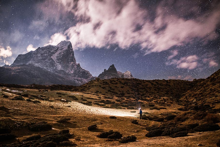 person on land near on mountain, gray and brown mountain during daytime HD wallpaper