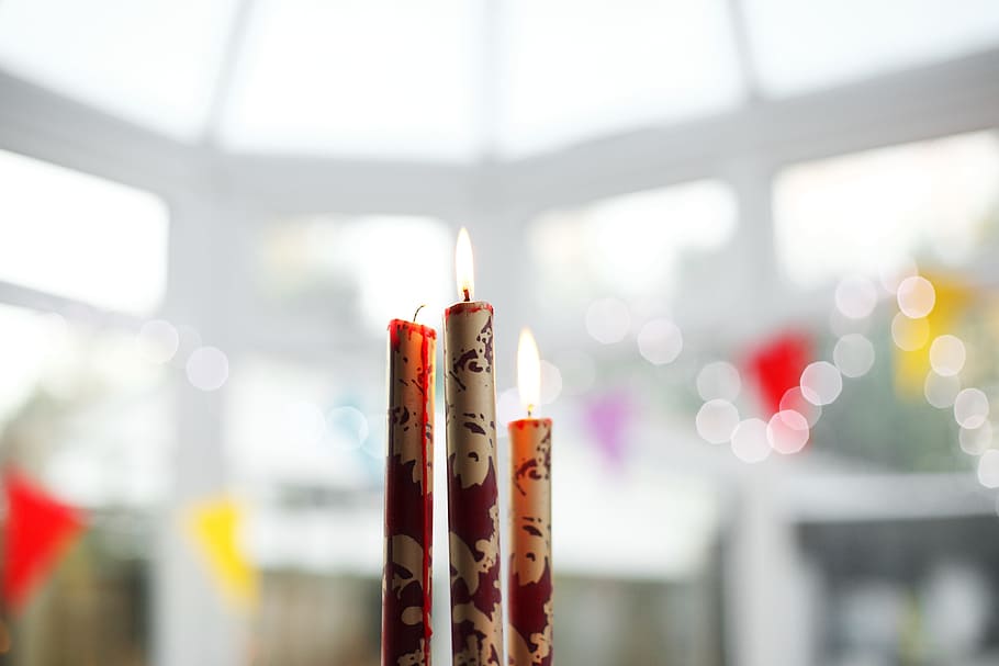 selective focus photography of three white-and-red lighted stick candles HD wallpaper