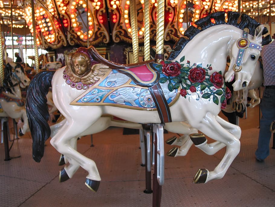 photo of white and blue horse carousel, empty, wooden, retro