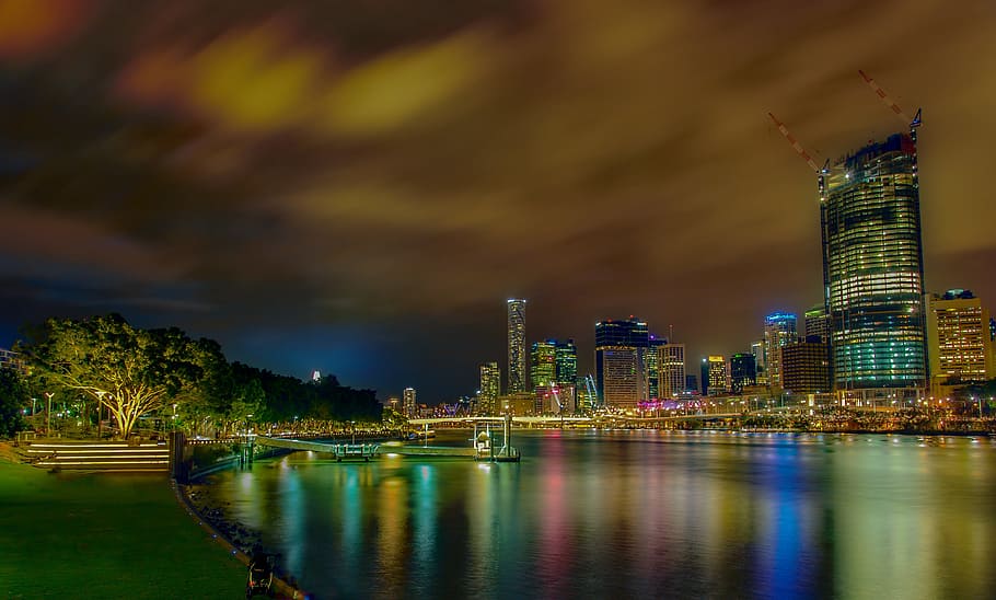 city lights reflecting on body of water, panoramic view of city buildings beside body of water nighttime HD wallpaper