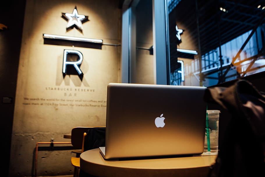 silver Apple MacBook, lowlight photography of silver MacBook on top of round side table HD wallpaper