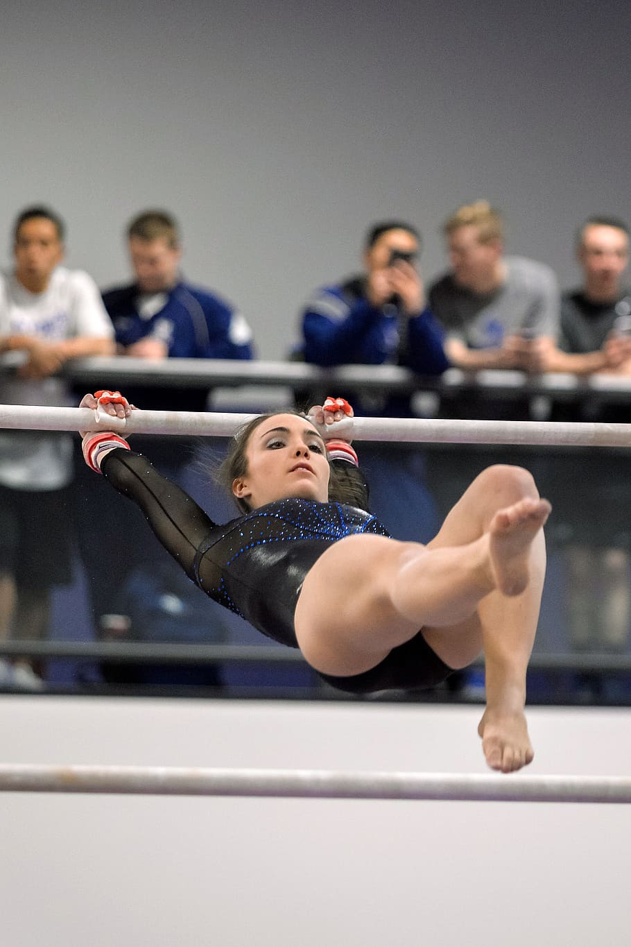 female gymnasts hanging on grey steel bar, gymnastics, performance