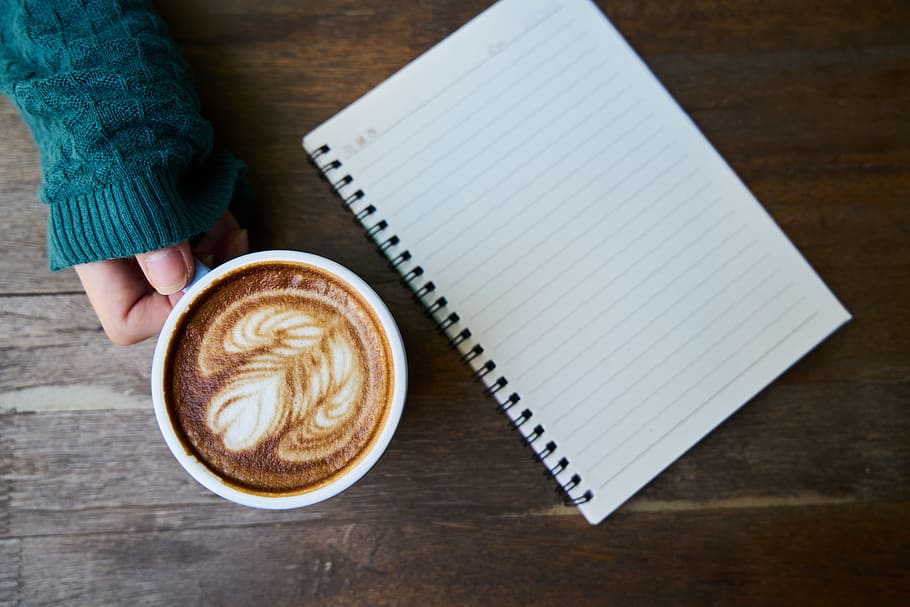 person holding white mug with coffee beside notebook, blue, beverage, HD wallpaper