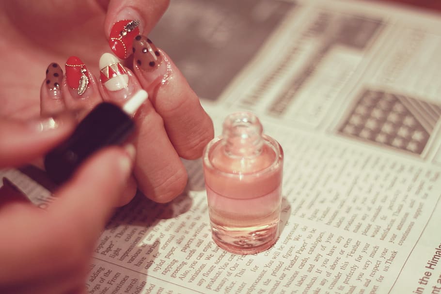shallow focus photography of nail polish bottle on top of newspaper HD wallpaper
