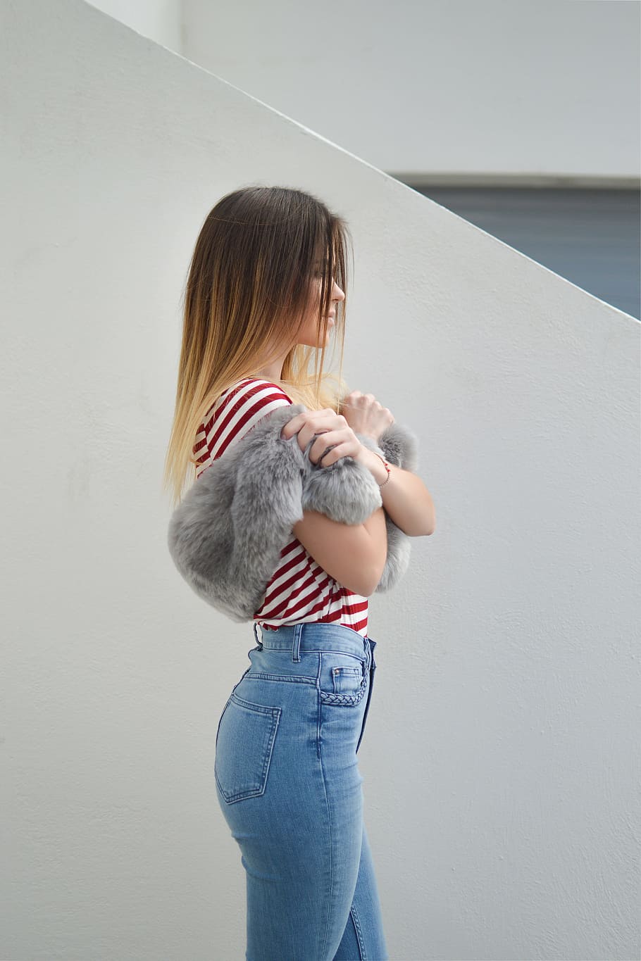 woman with pink fur scarf near wall, woman standing near white wall holding fur scarf HD wallpaper