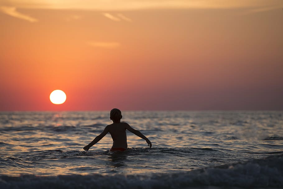 boy on body of water during sun set, beach, child, dawn, dusk HD wallpaper