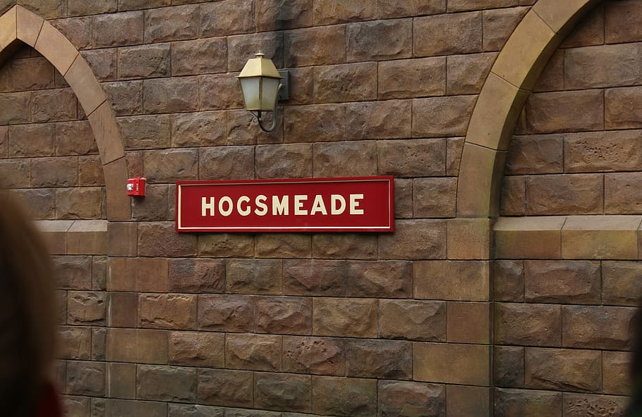red Hogsmeade signage on brick wall, train station, universal studios
