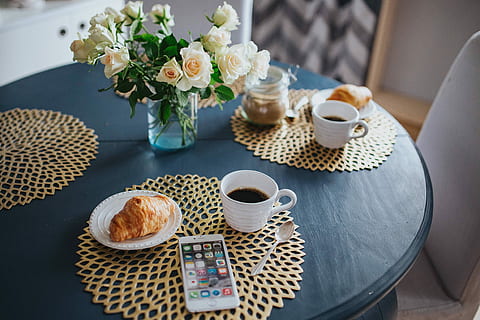 Round breakfast table with white flowers and golden coffee mats HD wallpaper