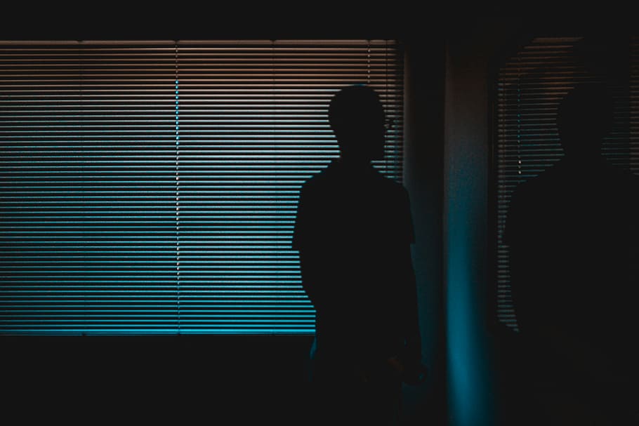 silhouette of man near window, man standing near vinyl window blinds