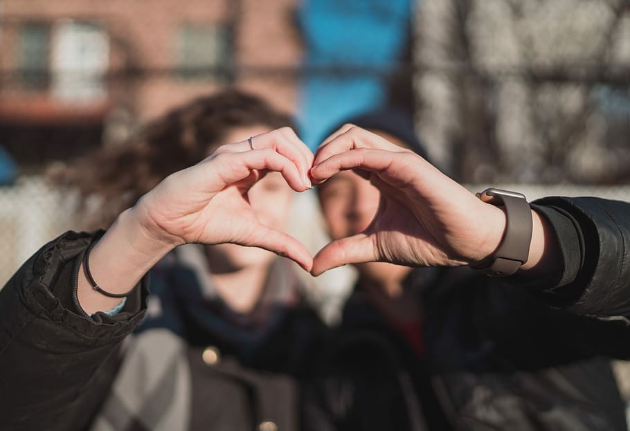 two person combine hand forming a heart hand gesture, selective focus photography of man and woman doing heart sign HD wallpaper
