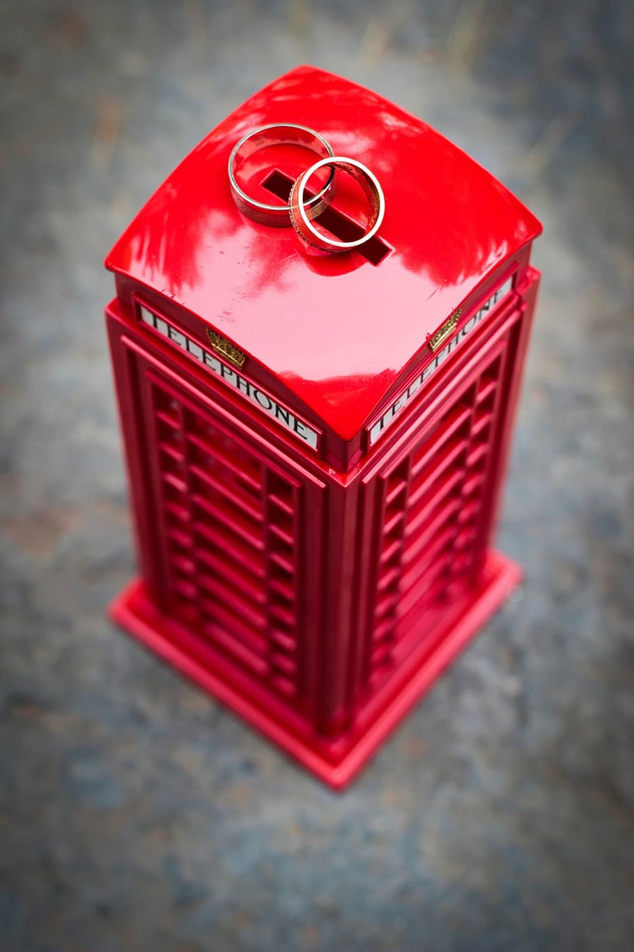 red and gray telephone booth coin bank and two silver-colored rings HD wallpaper