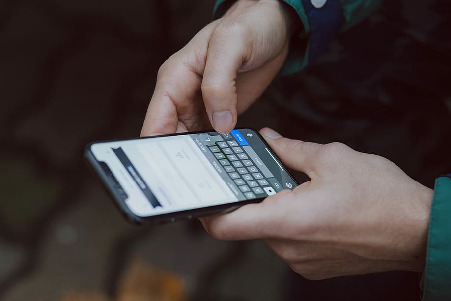 selective focus photography of person using smartphone, person holding iPhone X turned on HD wallpaper