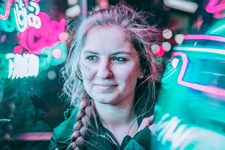 woman standing beside neon lights, woman wearing zip-up jacket