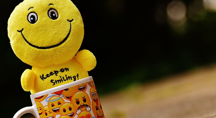 multicolored emoji-themed ceramic mug with emoji plush toy, smilies
