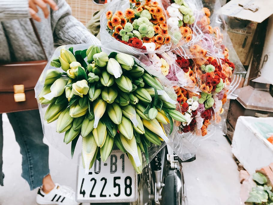 Spring is coming, yellow and green lily buds and assorted-color chrysanthemum flower bouquets on motorcycle HD wallpaper