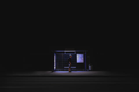 man waiting on shed during nightime, man in black shirt standing on waiting shed HD wallpaper