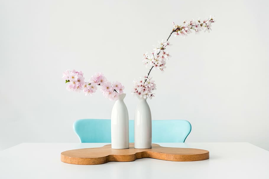 white and pink flowers in white ceramic vase, table, chair, indoor