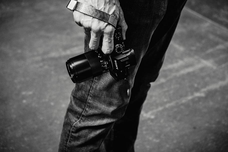 grayscale photo of person holding DSLR camera, man holding DSLR camera HD wallpaper