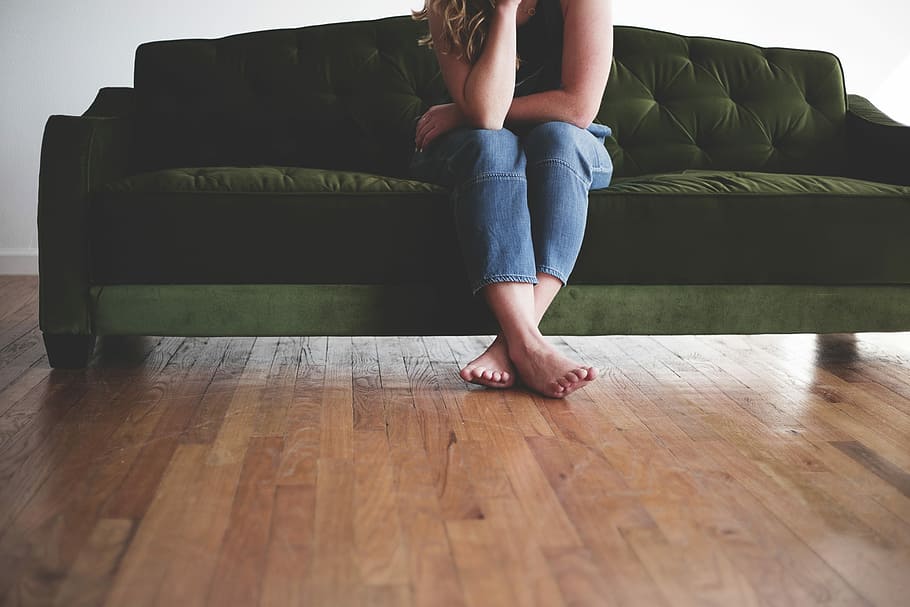 person sitting on couch, woman in blue jeans seating on green couch HD wallpaper