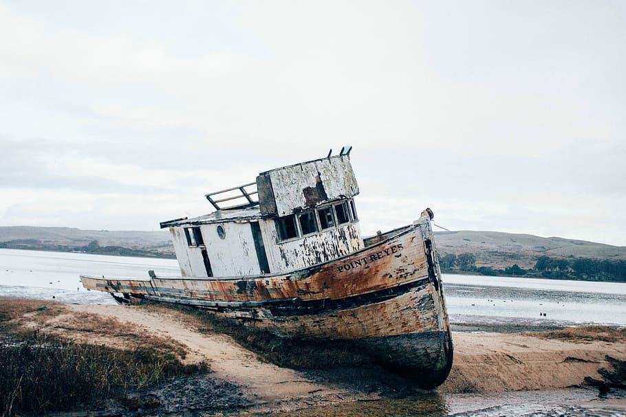 wrecked white and brown ship on sand, white and brown fishing boat near body of water background of mountain view HD wallpaper