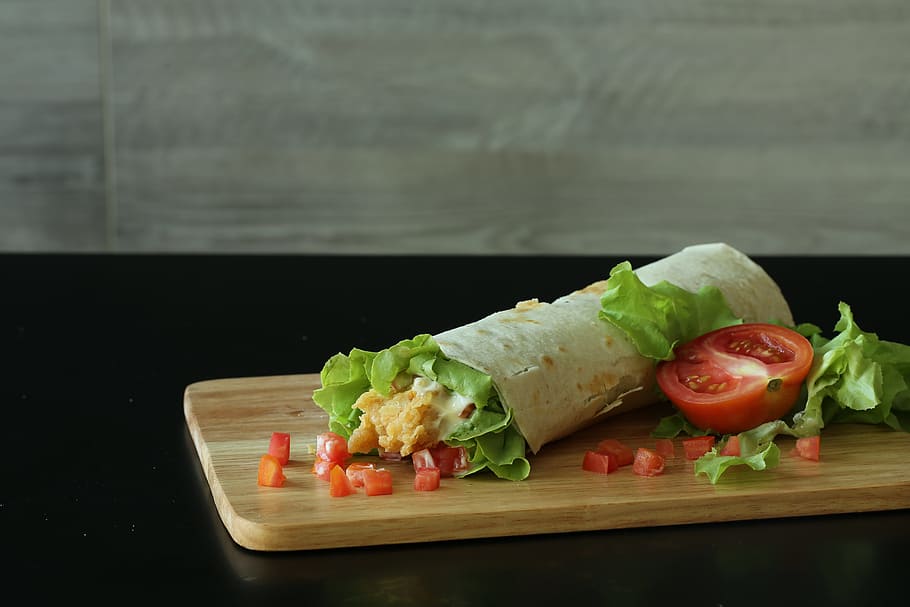 wrapped food with tomatoes and lettuce on brown wooden chopping board, HD wallpaper