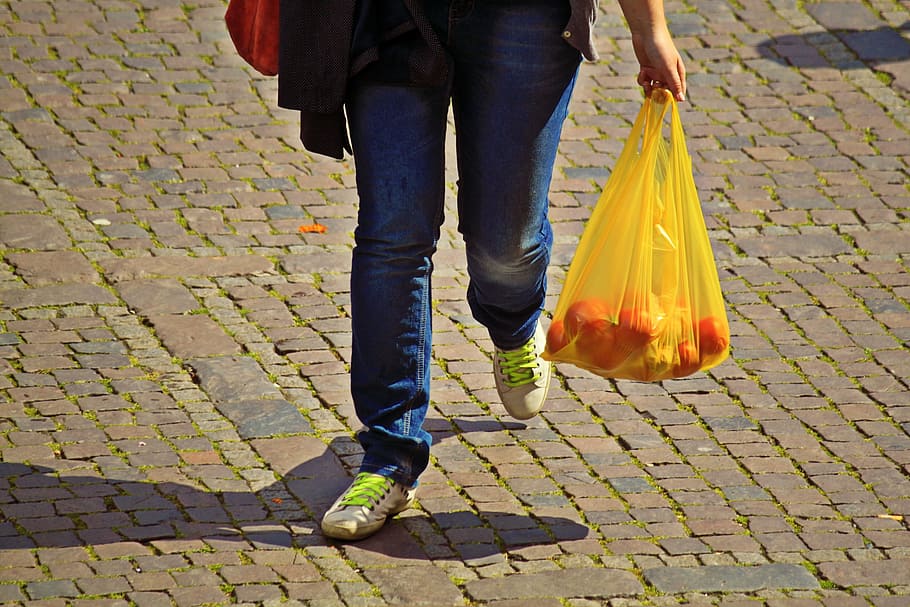 person holding yellow plastic bag, shopping, care, bear, market shopping
