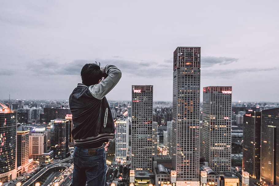 man looking at high-rise buildings during daytime, man taking photo of building HD wallpaper