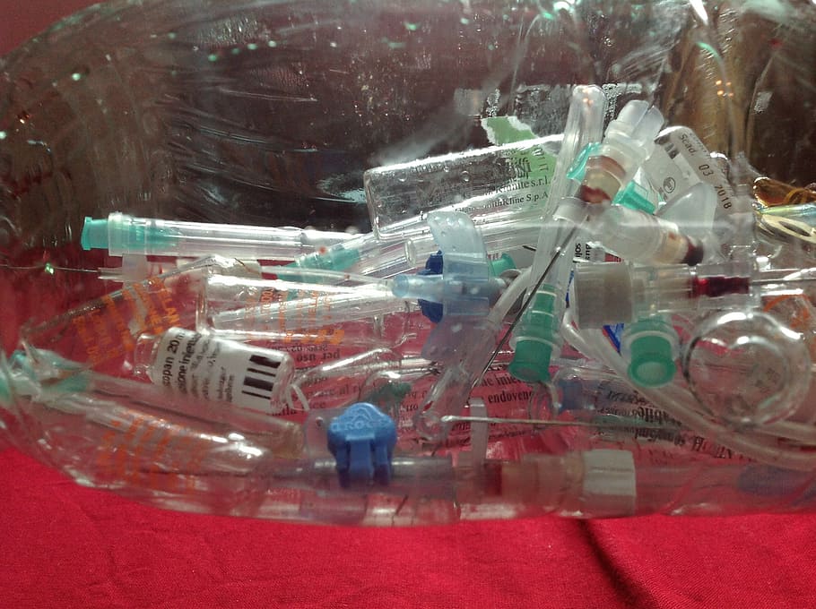 pile of clear bottles on red surface, syringes, injection, medical waste