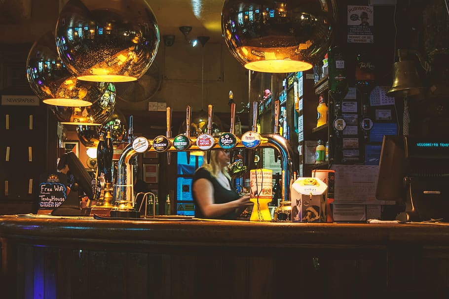 woman standing inside bar, woman in front of bar desk, warm, light HD wallpaper