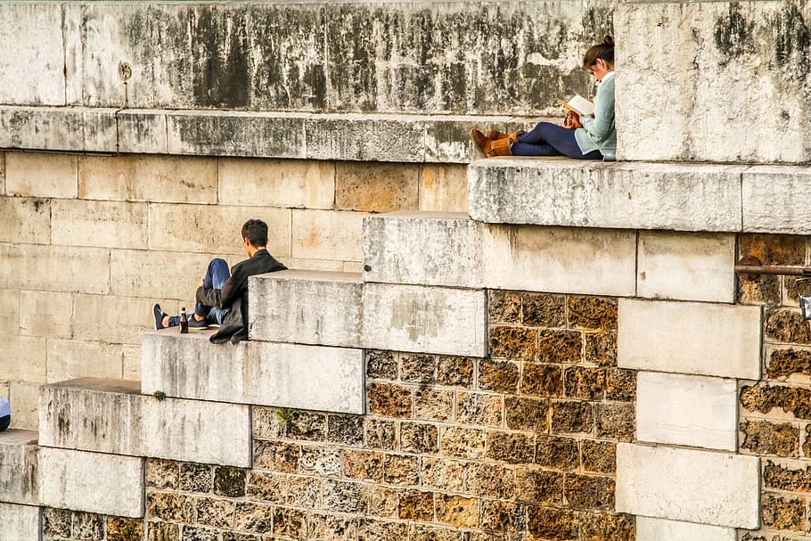 man sitting on staircase behind woman sitting on highest staircase, man and woman sitting on gray concrete stairs HD wallpaper