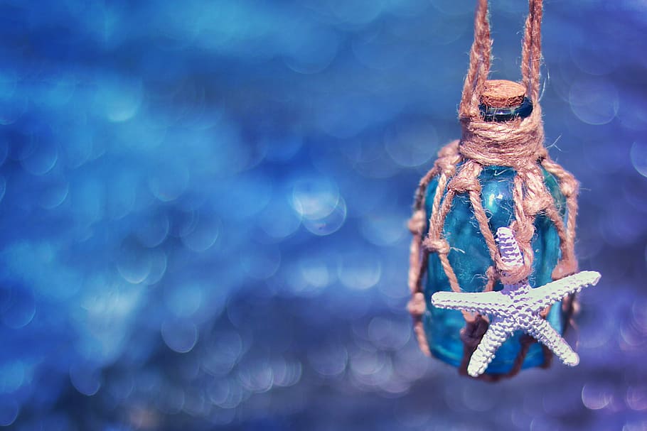 brown glass bottle wrapped in brown twine with white starfish suspended on air below blue surface, HD wallpaper