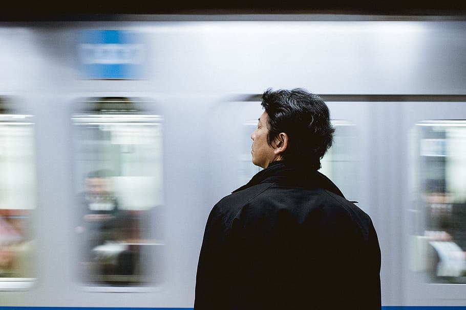 close-up photography of man standing front of train, man in black jacket standing near train HD wallpaper
